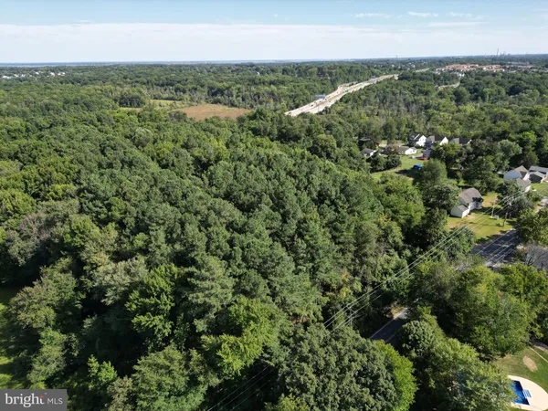 an aerial view of a houses with yard and ocean view