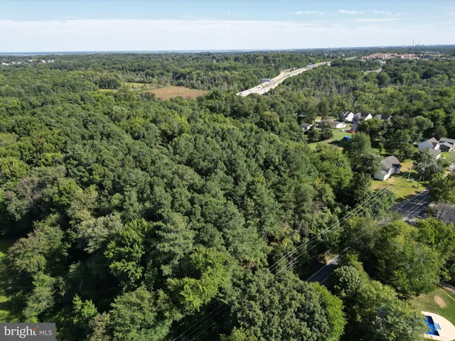 an aerial view of a houses with yard and ocean view