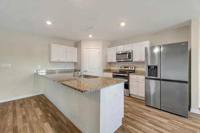 a kitchen with a sink a microwave a refrigerator and cabinets