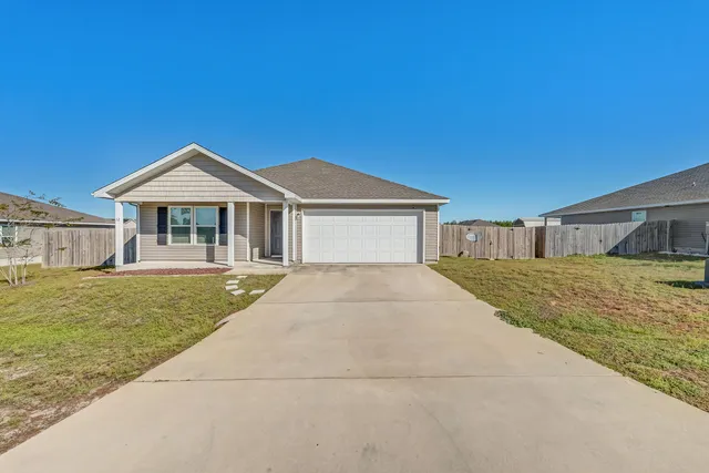 a front view of a house with a garden and yard