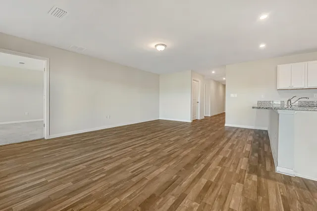 a view of empty room with wooden floor