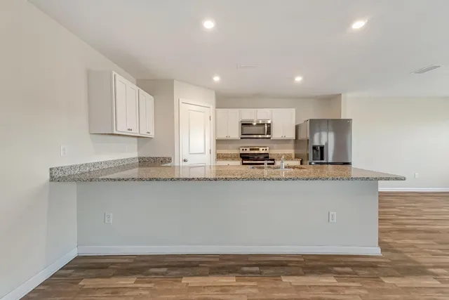 a kitchen with stainless steel appliances granite countertop a stove a sink and a granite counter tops with white countertops