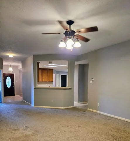an empty room with window and a ceiling fan