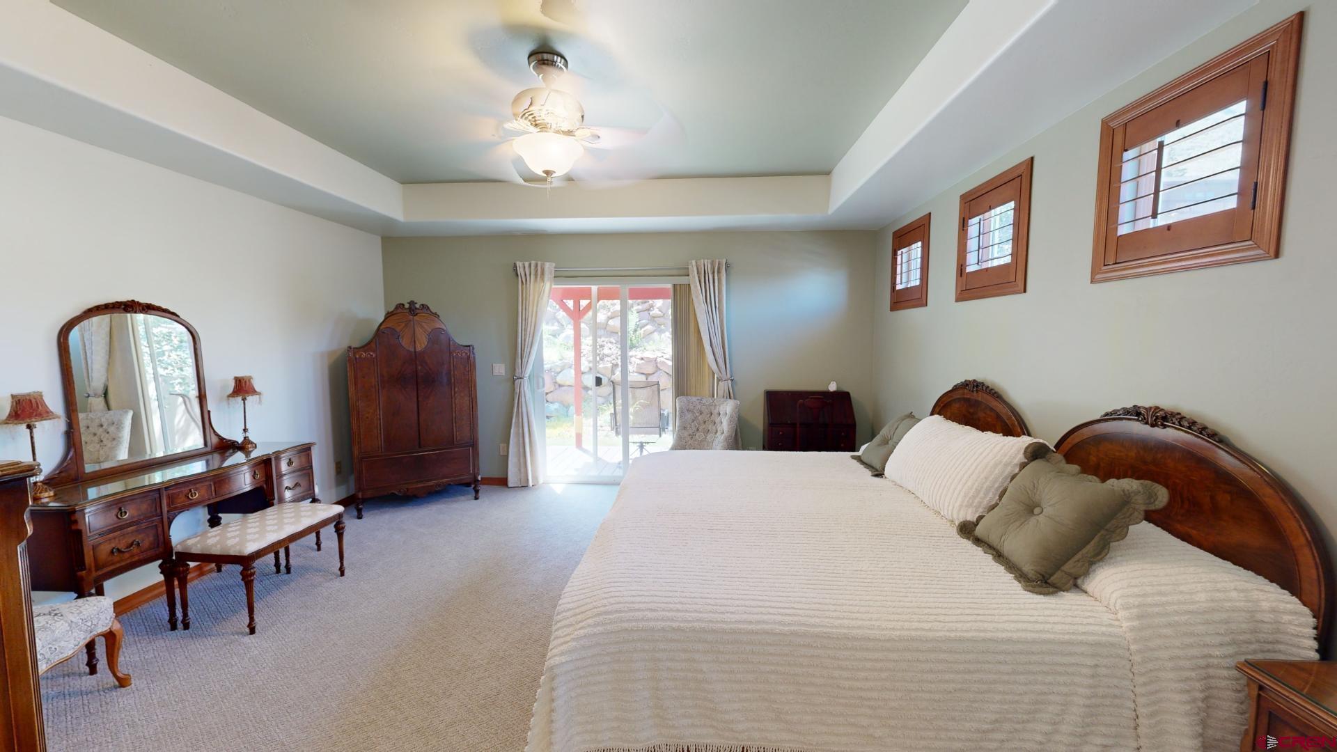222 Jenkins Ranch Road Durango, CO 81301 - Photo 16 of 30 a bedroom with a bed and a chandelier