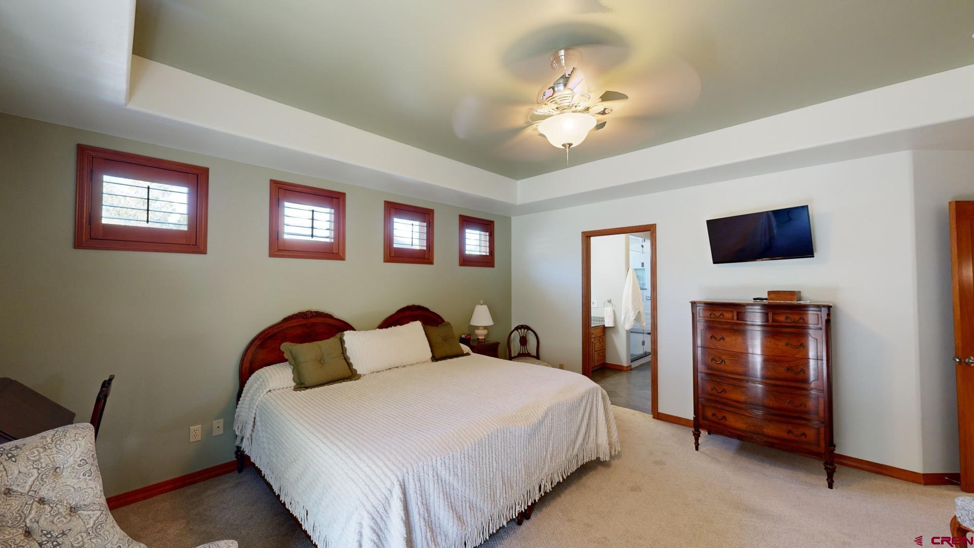 222 Jenkins Ranch Road Durango, CO 81301 - Photo 18 of 30 a bedroom with a bed and a chandelier