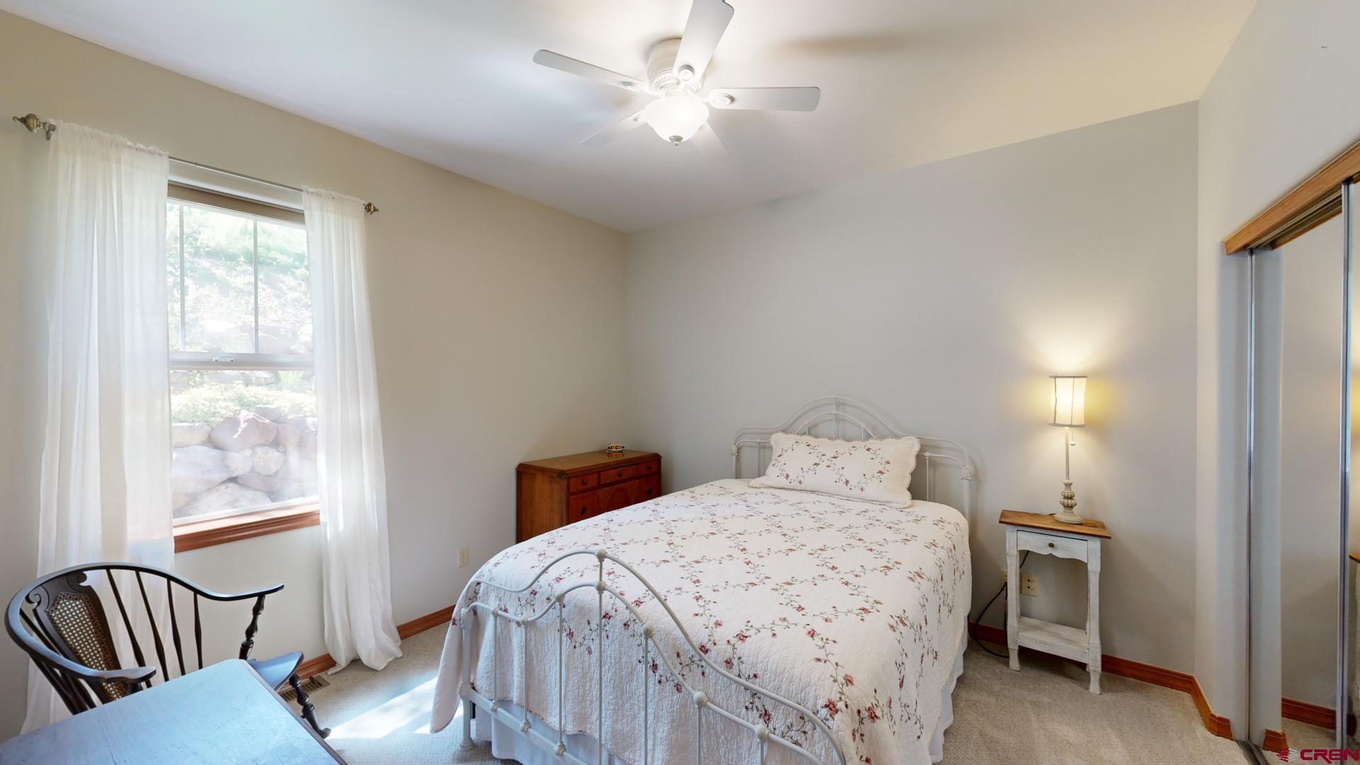 222 Jenkins Ranch Road Durango, CO 81301 - Photo 21 of 30 a bedroom with a bed and a chandelier