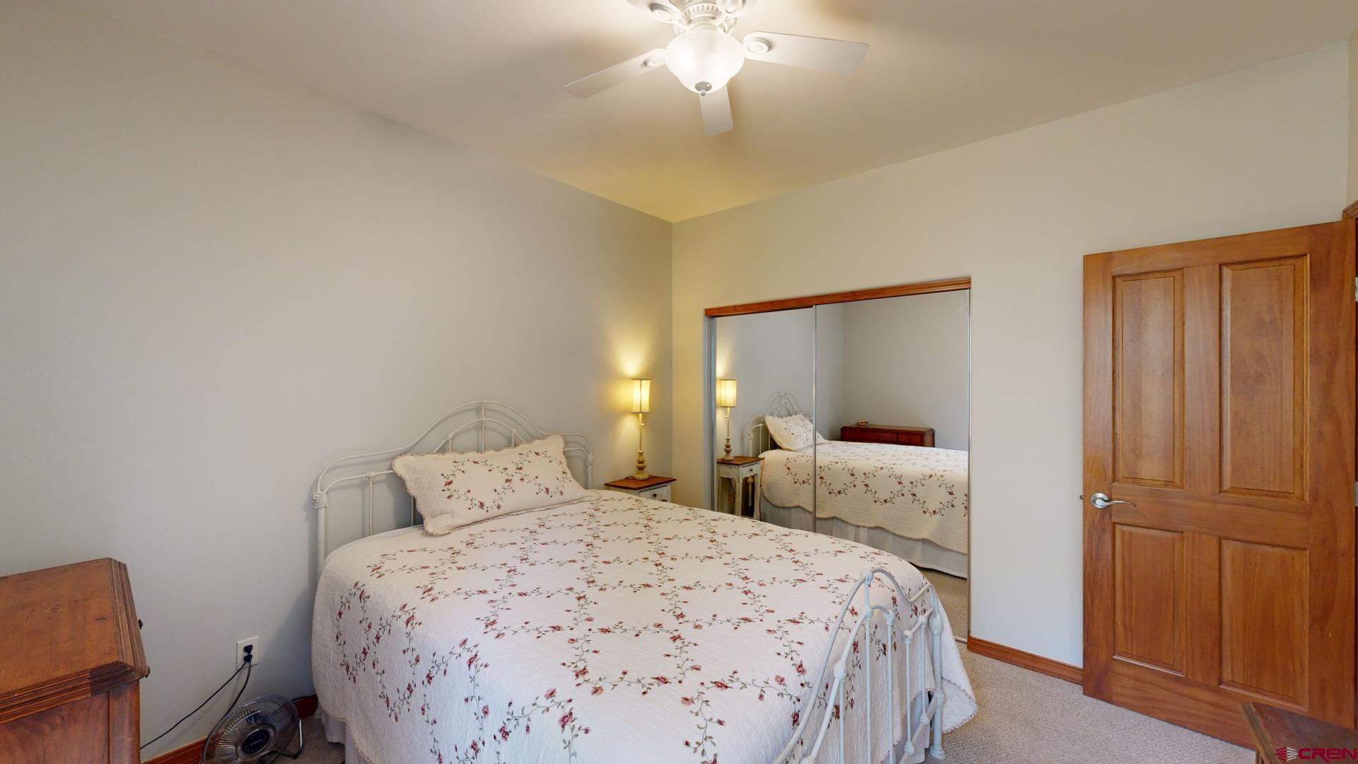 222 Jenkins Ranch Road Durango, CO 81301 - Photo 22 of 30 a bedroom with a bed and a chandelier