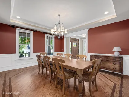 a view of a dining room with furniture a chandelier and wooden floor