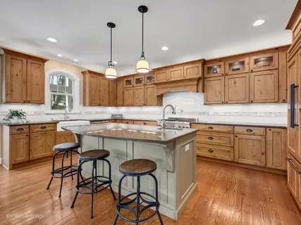 a kitchen with granite countertop wooden floors cabinets a dining table and chairs