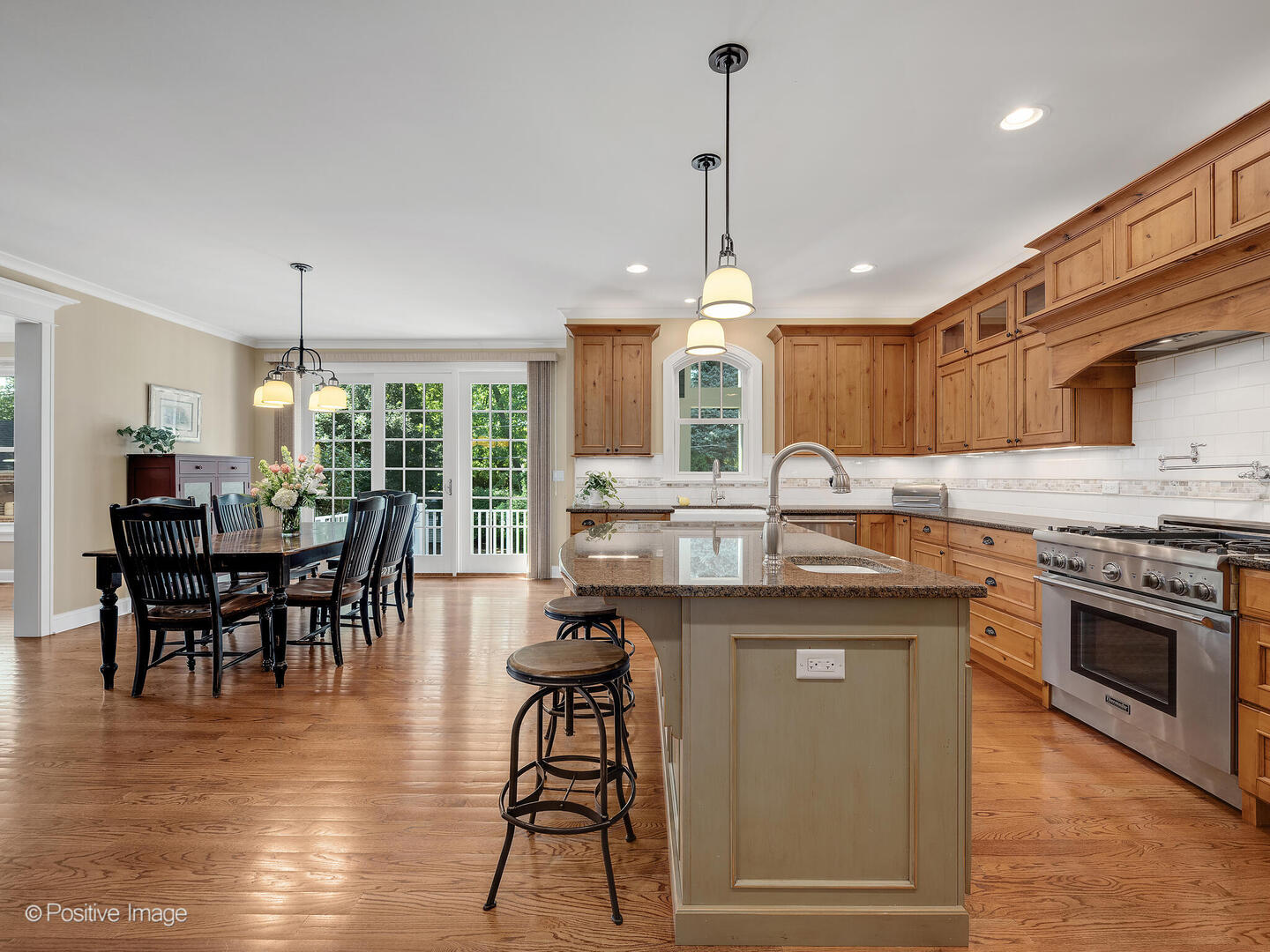 610 Washington Street Elmhurst, IL 60126 - Photo 27 of 48 a kitchen with kitchen island granite countertop a stove a sink a dining table and chairs with wooden floor