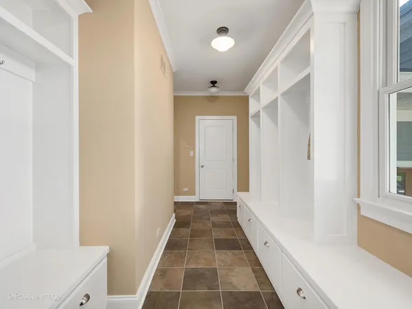 a view of a hallway with wooden floor and a bathroom