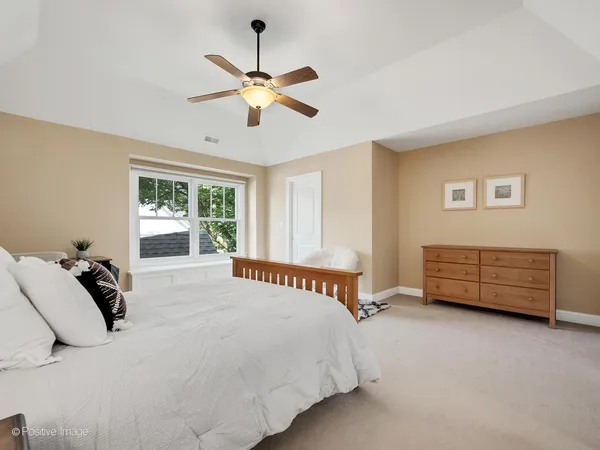 a bedroom with a bed a chandelier and a window