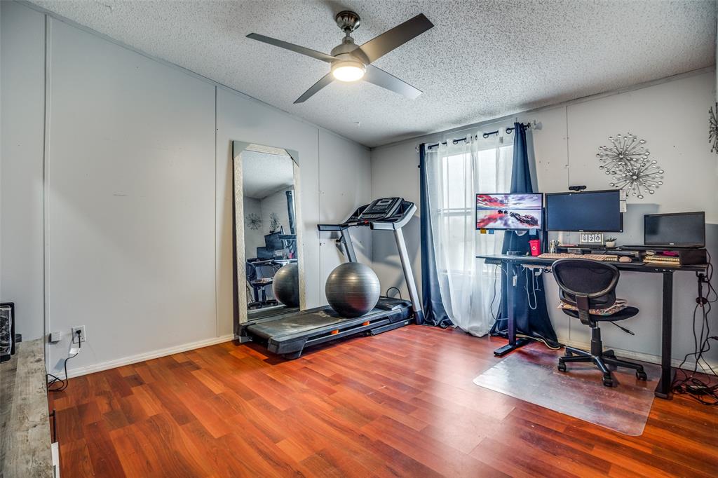 458 County Road 2131 Valley View, TX 76272 - Photo 11 of 13 Third bedroom with vinyl flooring, ceiling fan, walk-in closet, and a window that fills the room with natural light. Generously sized for comfort and functionality