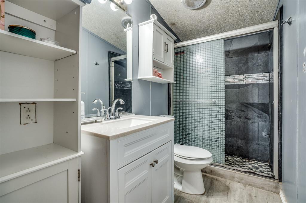 458 County Road 2131 Valley View, TX 76272 - Photo 12 of 13 Second bathroom featuring a walk-in shower with tile and a glass sliding door, combining style and functionality.