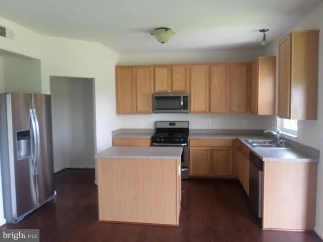 a kitchen with stainless steel appliances granite countertop a refrigerator a stove top oven a sink and dishwasher