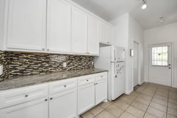 a kitchen with granite countertop white cabinets and white appliances