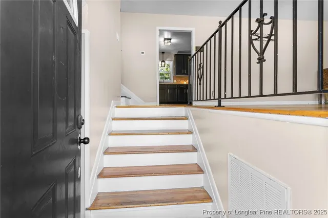 a view of staircase with white walls and railing