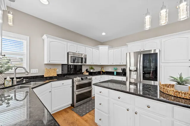 a kitchen with stainless steel appliances granite countertop a refrigerator and a stove