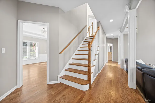 a kitchen with granite countertop white cabinets refrigerator and chairs