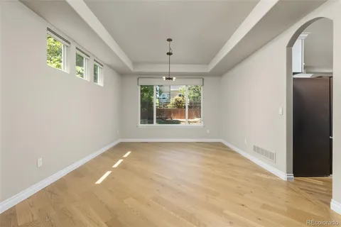 an empty room with windows and chandelier