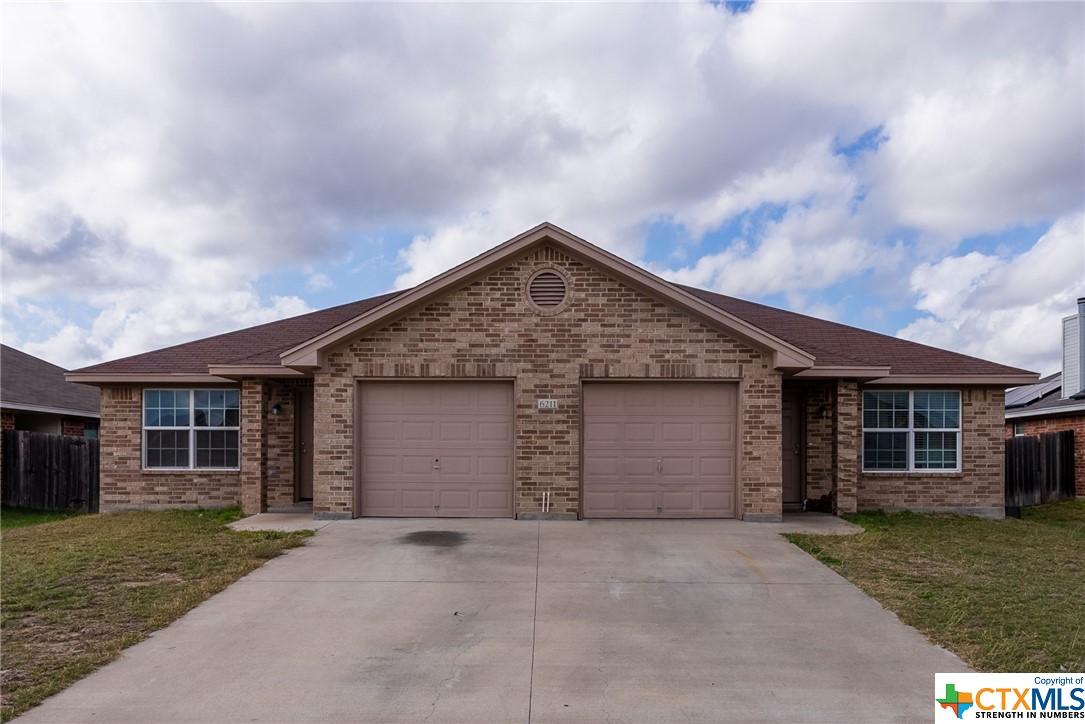 a backyard of a house with garage and barbeque oven