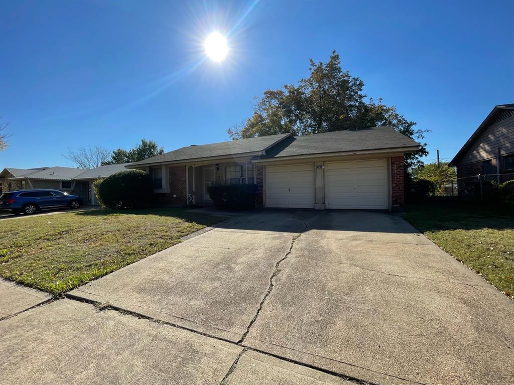 Ranch-style house with a front yard and a garage