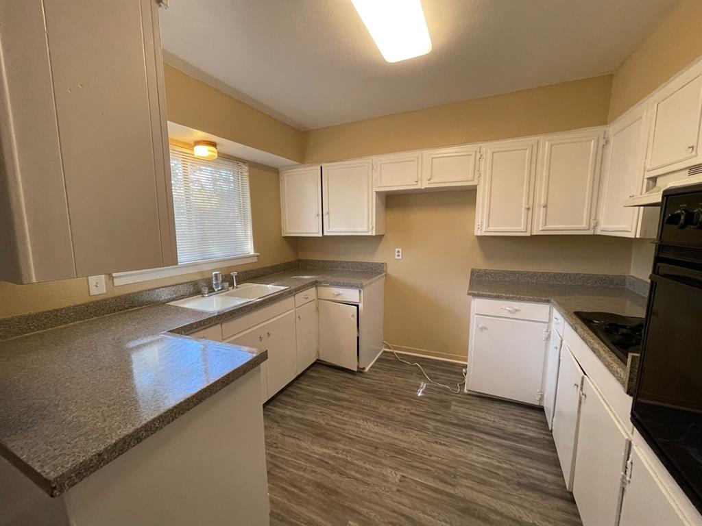 2310 Gilbert Circle Arlington, TX 76010 - Photo 3 of 9 Kitchen with white cabinets, dark hardwood / wood-style floors, kitchen peninsula, and sink