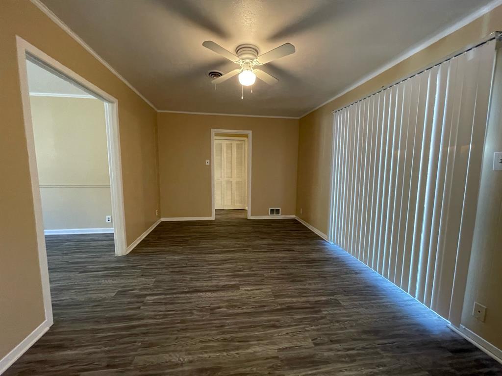2310 Gilbert Circle Arlington, TX 76010 - Photo 4 of 9 Empty room with ceiling fan, dark wood-type flooring, and ornamental molding