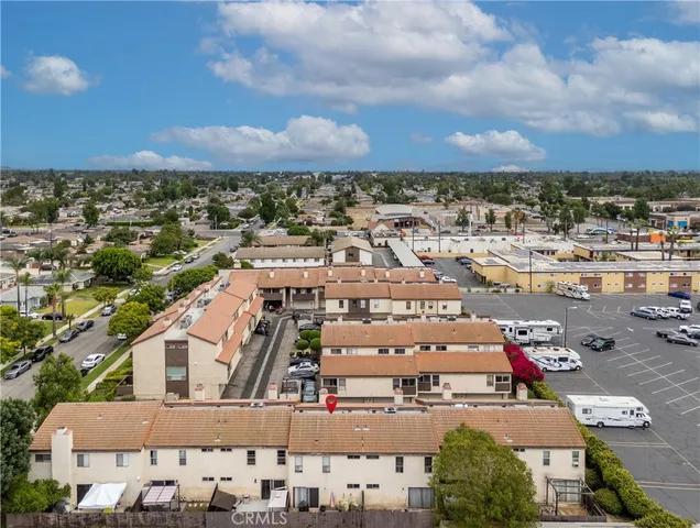 an aerial view of a city with lots of residential buildings and mountain view in back
