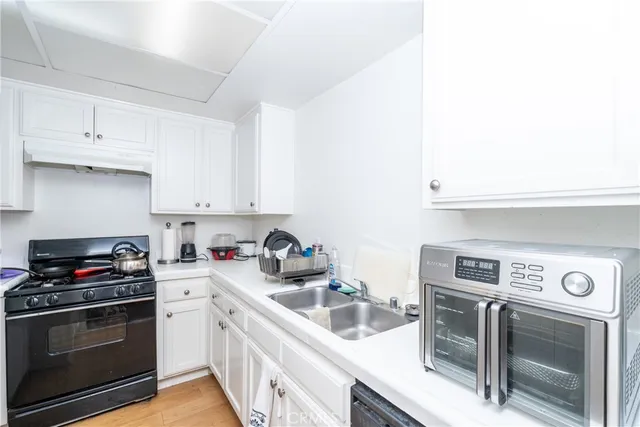 a kitchen with a sink a stove and cabinets