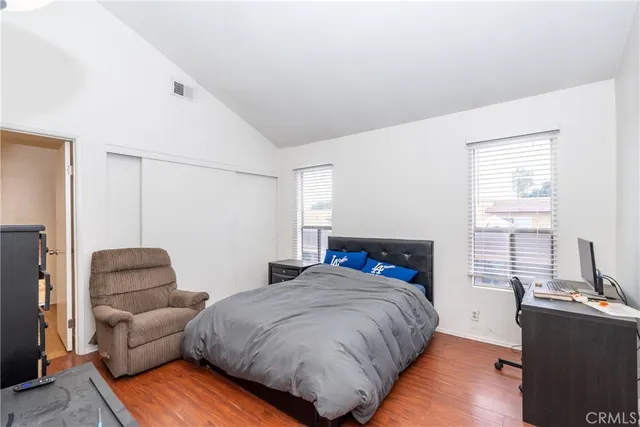 a bedroom with a bed and a flat tv screen on the dresser