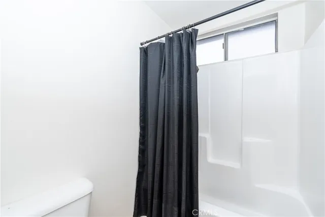 a bedroom with a bed and a flat tv screen on dresser