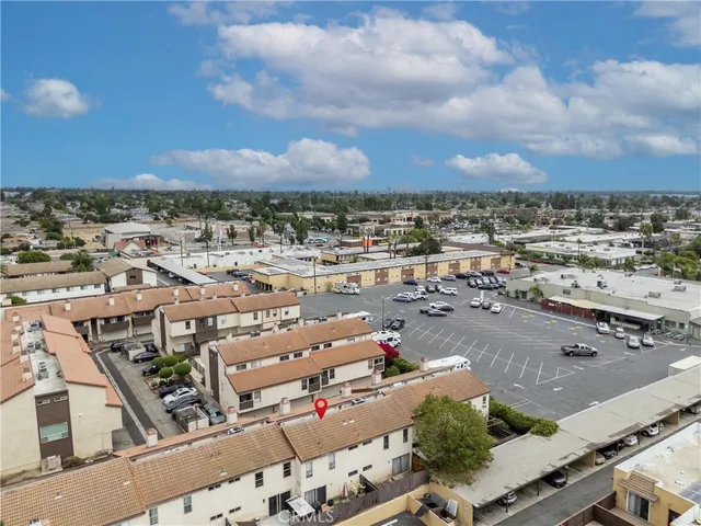 an aerial view of a city with lots of residential buildings and mountain view in back