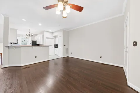 a kitchen with stainless steel appliances granite countertop a refrigerator a stove and white cabinets with wooden floor