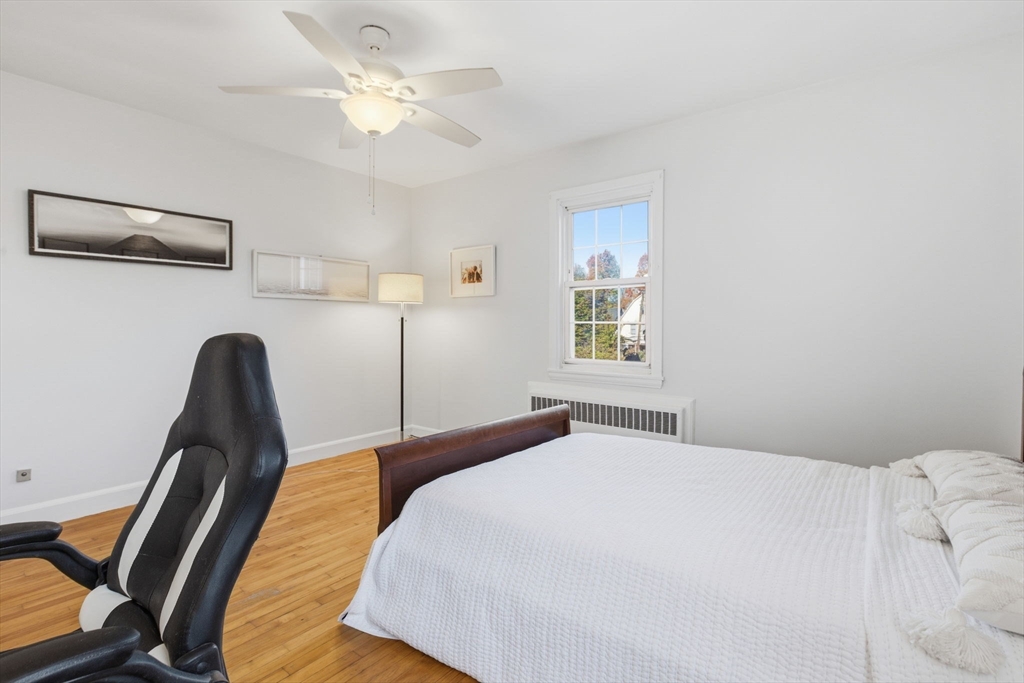 112 Maple Street, Unit 6 Malden, MA 02148 - Photo 19 of 22 a bedroom with a bed a chandelier and chair