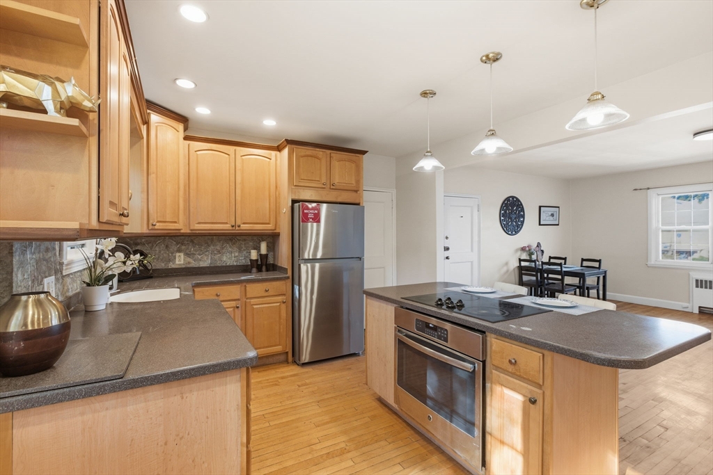 112 Maple Street, Unit 6 Malden, MA 02148 - Photo 4 of 22 a kitchen with stainless steel appliances granite countertop a sink stove and refrigerator