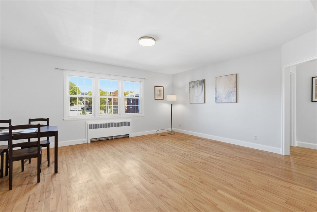 112 Maple Street, Unit 6 Malden, MA 02148 - Photo 6 of 22 an empty room with wooden floor and windows