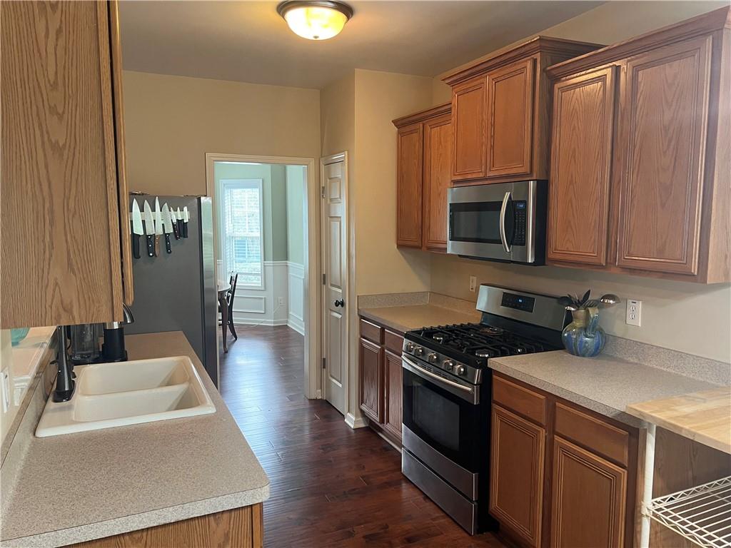 113 Nelson Ridge Drive Ball Ground, GA 30107 - Photo 11 of 33 a kitchen with stainless steel appliances a stove a sink dishwasher a microwave oven and a refrigerator with wooden floor