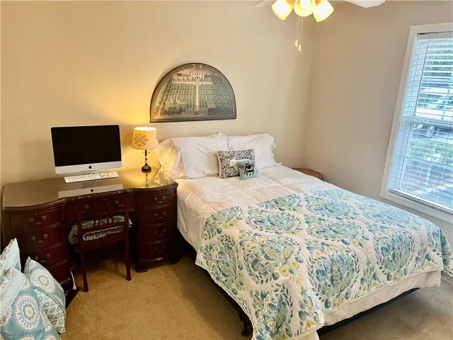 a bedroom with a bed and a flat tv screen on dresser