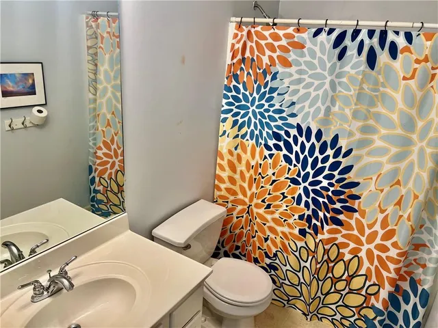 a bathroom with a toilet and a sink a mirror