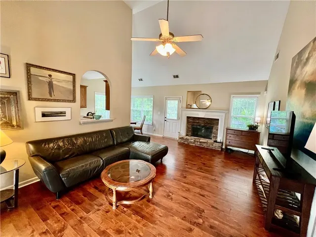a living room with furniture fireplace and wooden floor