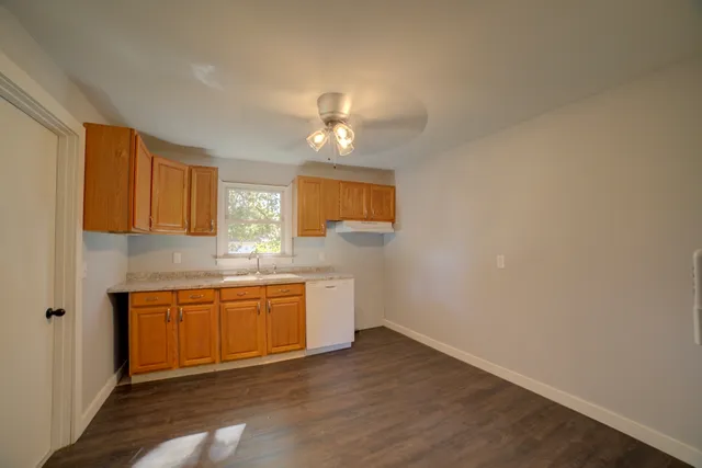 a kitchen with a sink cabinets and wooden floor