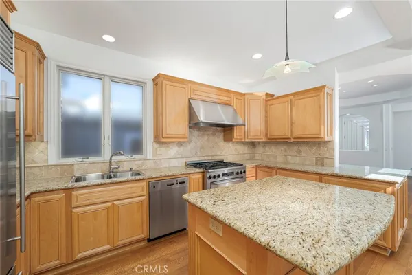 a kitchen with stainless steel appliances granite countertop wooden cabinets a sink and dishwasher