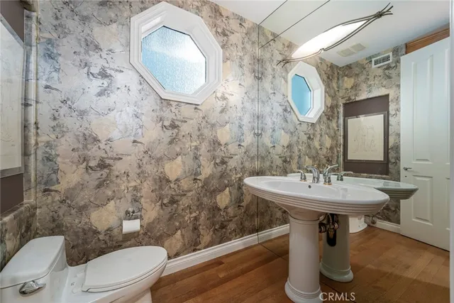 a bathroom with a sink a toilet and mirror