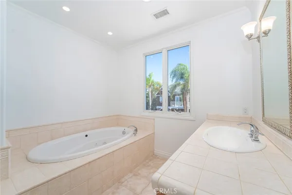 a bathroom with a granite countertop tub a sink and a window