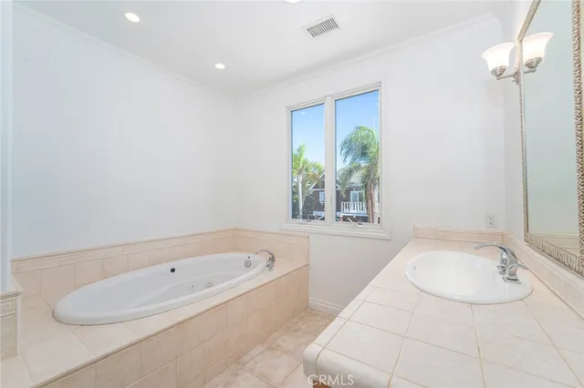 a bathroom with a granite countertop tub a sink and a window