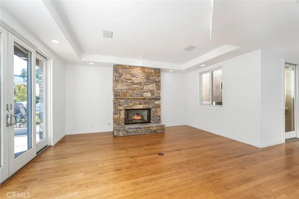 wooden floor fireplace and windows in an empty room