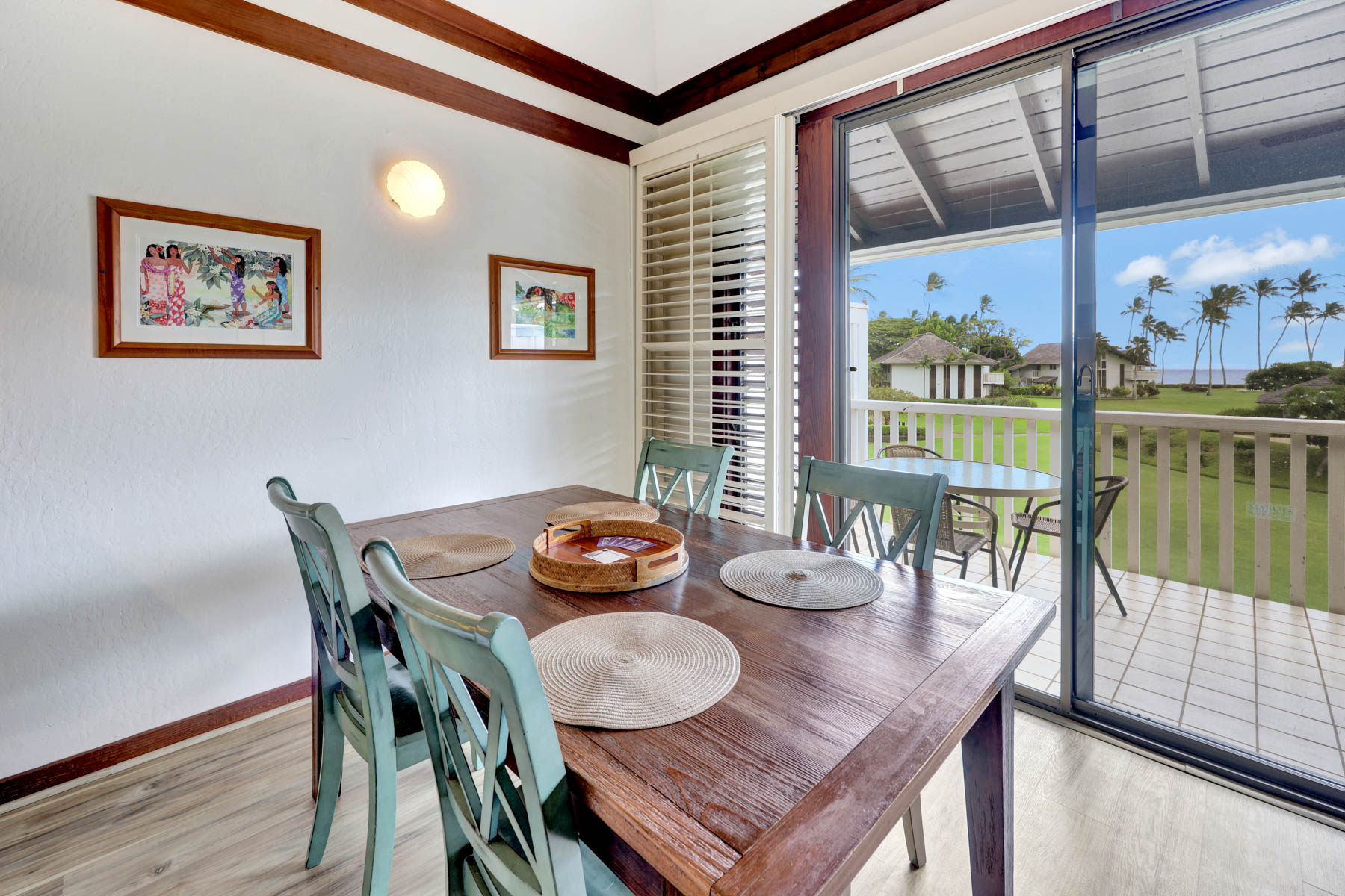 a view of a dining room with furniture a large window and wooden floor