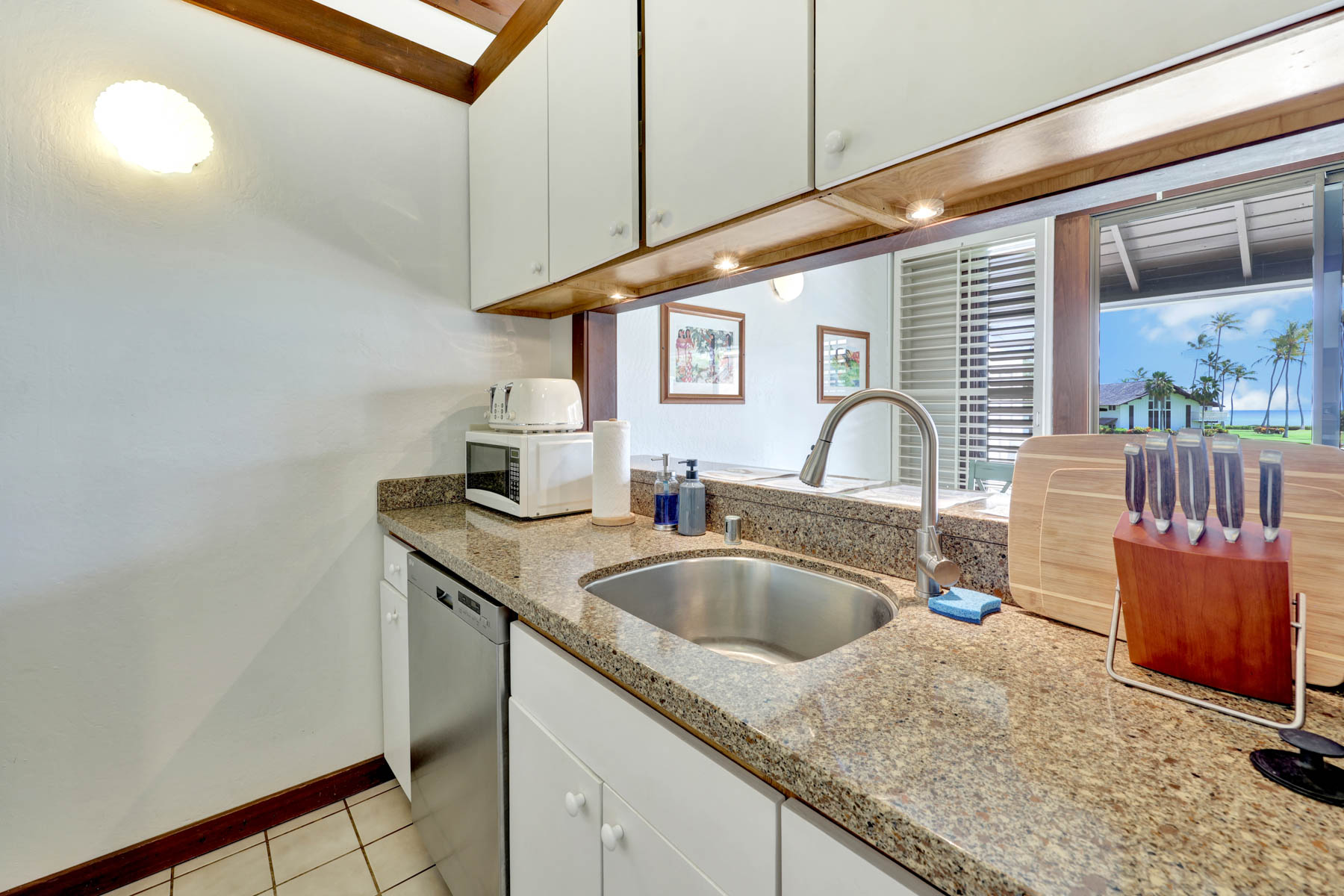 2253 Poipu Road, Unit 138 Koloa, HI 96756 - Photo 11 of 27 a kitchen with stainless steel appliances granite countertop a sink and a wooden cabinets