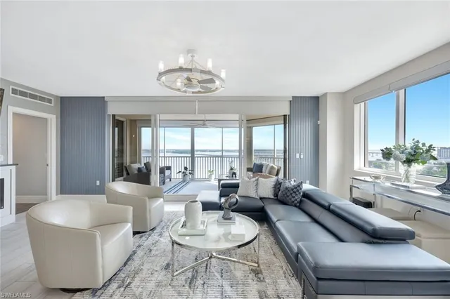 a living room with furniture chandelier and a large window